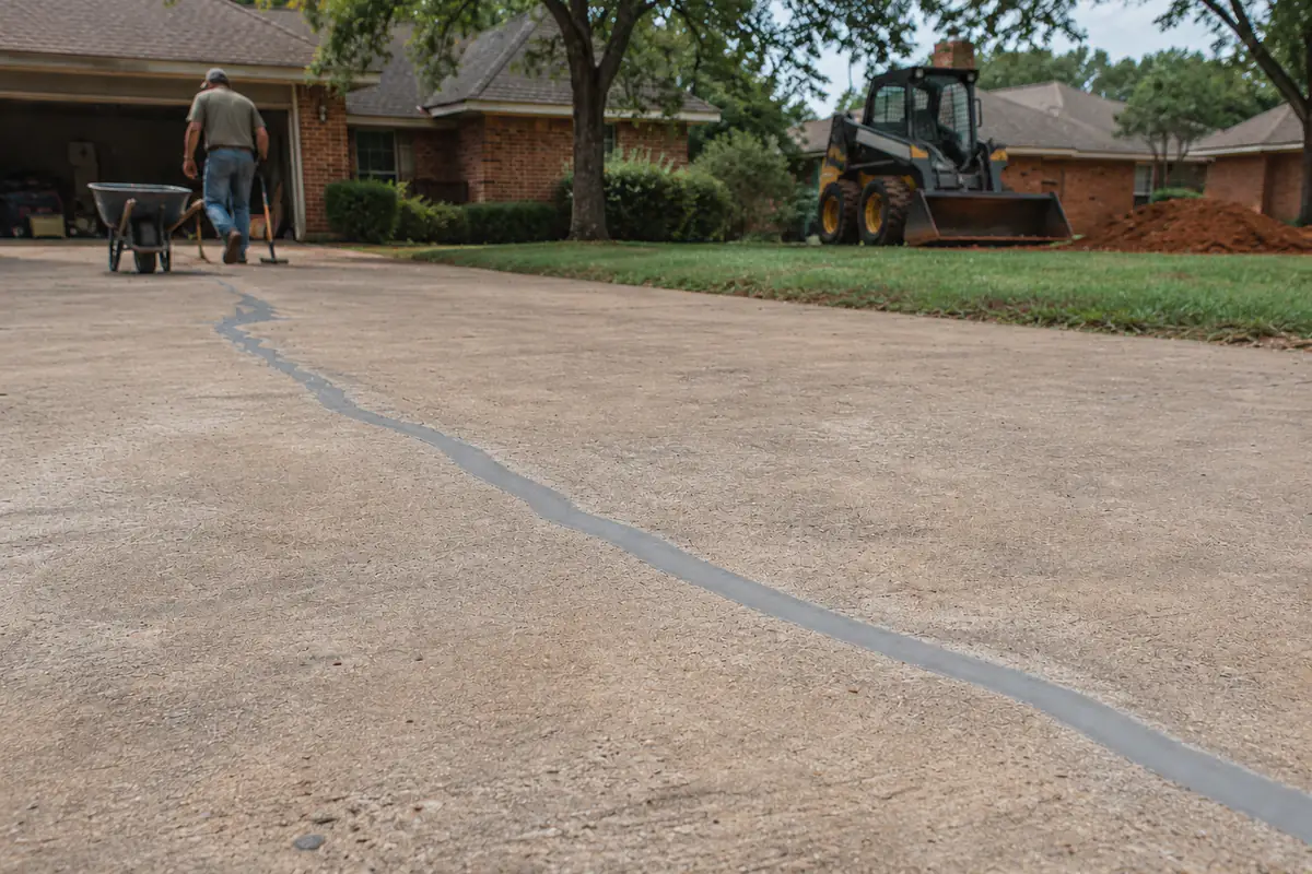 After: the crack cleaned, routed and filled flush with smooth gray polyurethane sealant, weeds gone