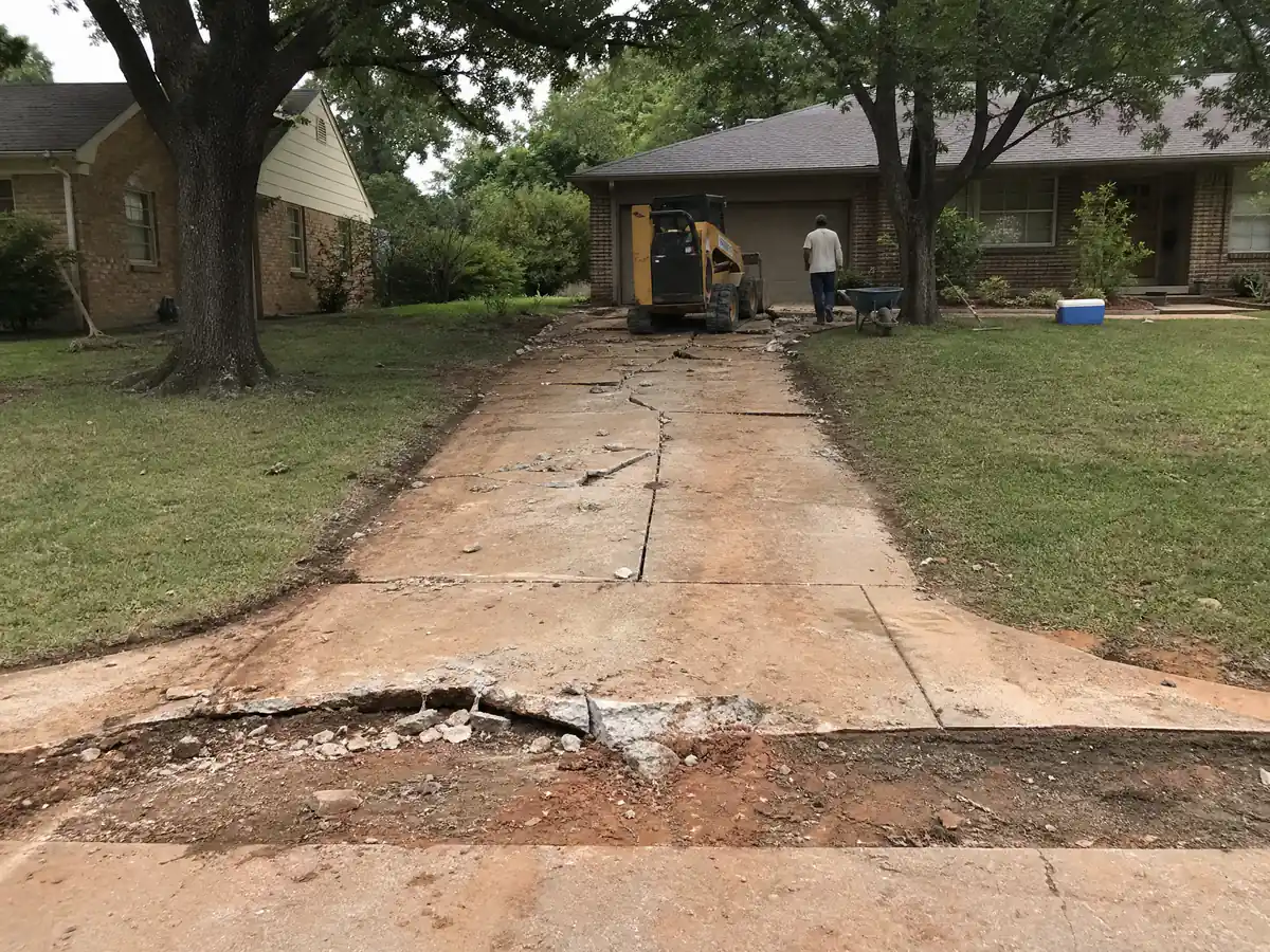 Narrow cracked driveway and apron at a 1960s ranch house in The Village, Oklahoma