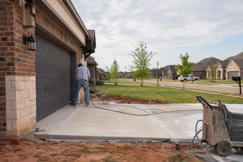 Concrete driveway settling at the garage in a 2010s rebuilt subdivision in Moore, Oklahoma