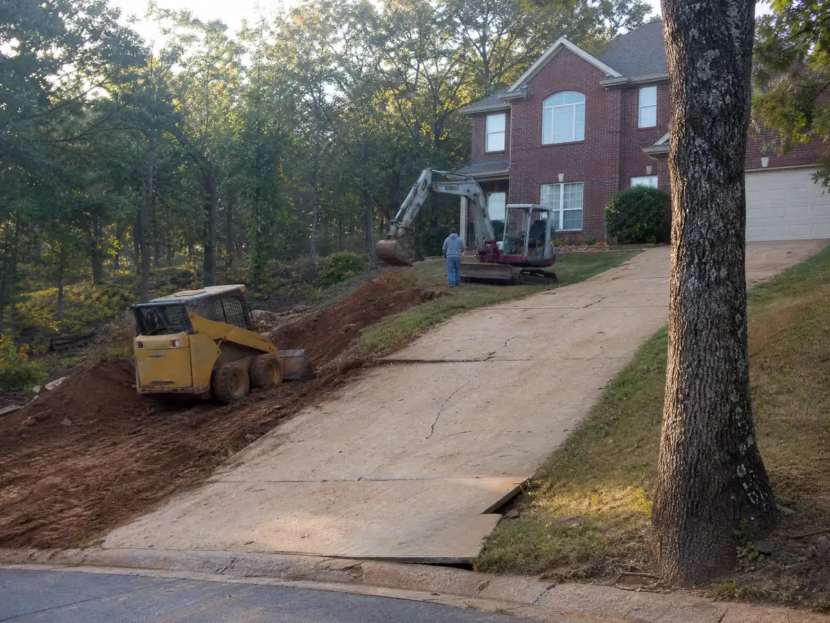 Sloped concrete driveway on a wooded hillside lot with post oaks in Edmond, Oklahoma